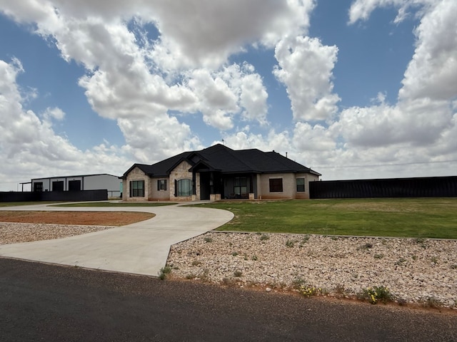 single story home with a front yard and curved driveway