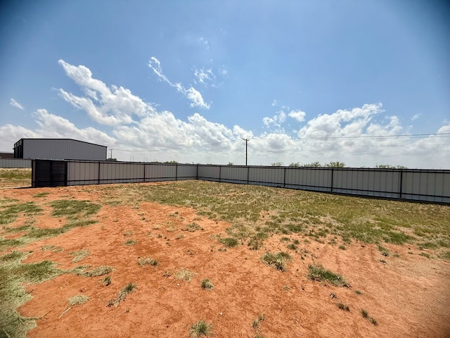 view of yard with an outbuilding, a pole building, and fence