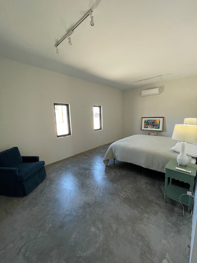 1402 W Philadelphia St, Marfa, TX 79843 - bedroom with rail lighting, concrete flooring, and a wall mounted air conditioner