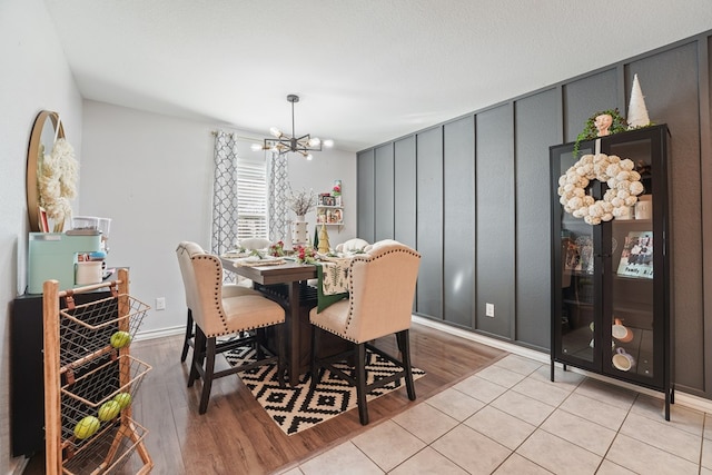 dining area with light tile patterned flooring and a chandelier