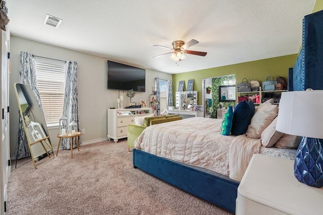 carpeted bedroom with multiple windows and ceiling fan