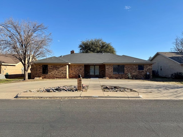 4612 Fountain Ln, Odessa, TX 79761 - ranch-style home featuring curved driveway, a chimney, and brick siding