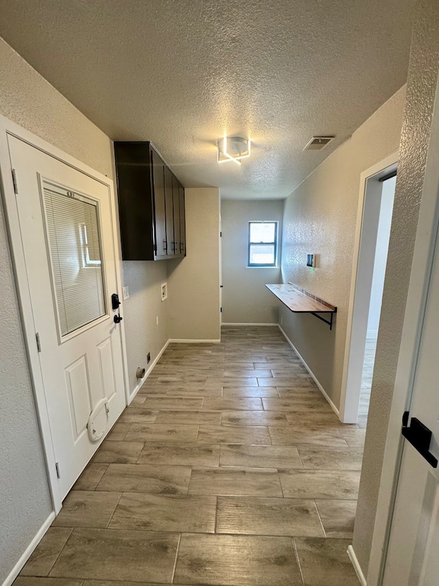 4612 Fountain Ln, Odessa, TX 79761 - laundry room featuring wood finished floors, a textured ceiling, and a textured wall