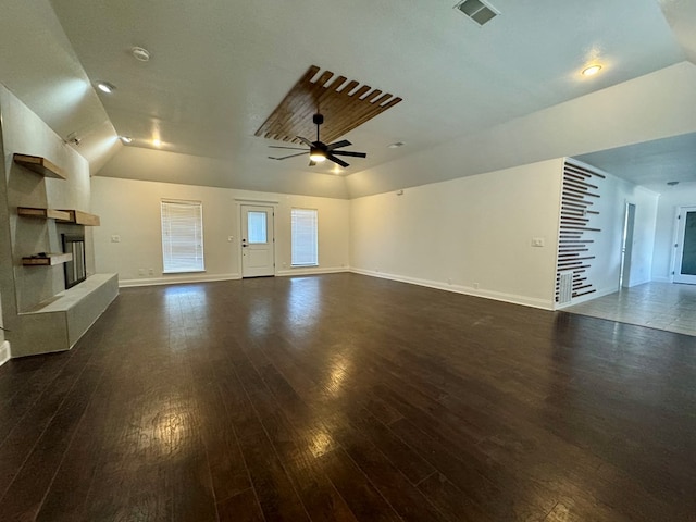 4612 Fountain Ln, Odessa, TX 79761 - unfurnished living room featuring dark wood-style floors, vaulted ceiling, ceiling fan, and a tile fireplace