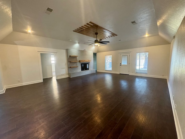 4612 Fountain Ln, Odessa, TX 79761 - unfurnished living room featuring vaulted ceiling, dark wood-type flooring, a glass covered fireplace, ceiling fan, and a textured ceiling