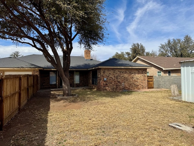 4612 Fountain Ln, Odessa, TX 79761 - back of property with a fenced backyard, brick siding, and a chimney