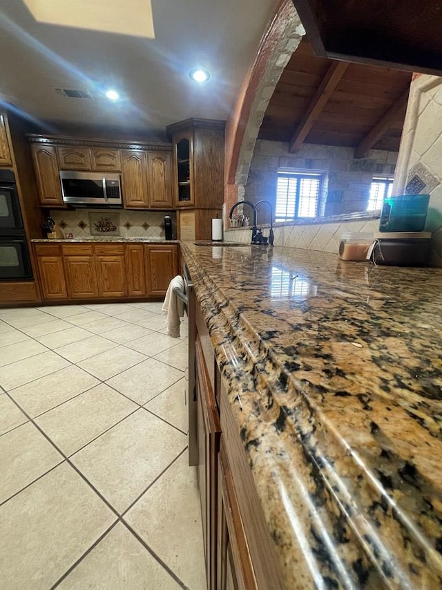 3934 N Bucknell Ave, Odessa, TX 79764 - kitchen with stainless steel appliances, backsplash, light tile patterned floors, glass insert cabinets, and a sink