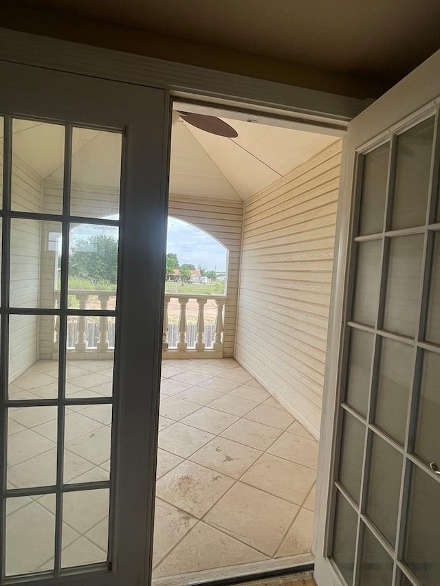 3934 N Bucknell Ave, Odessa, TX 79764 - doorway with wooden walls, light tile patterned floors, ceiling fan, and plenty of natural light