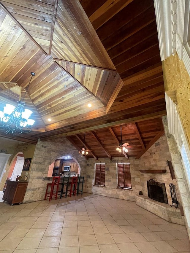 3934 N Bucknell Ave, Odessa, TX 79764 - living area featuring wood ceiling, arched walkways, a stone fireplace, a chandelier, and tile patterned flooring