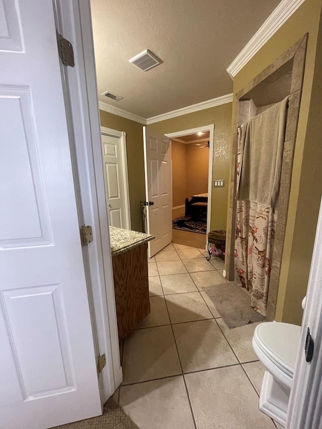 3934 N Bucknell Ave, Odessa, TX 79764 - bathroom featuring vanity, crown molding, toilet, tile patterned floors, and a textured ceiling
