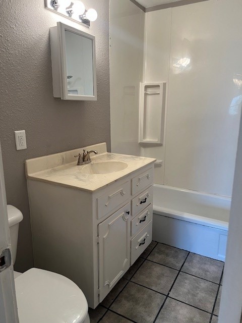 full bath featuring toilet, bathtub / shower combination, tile patterned flooring, and vanity