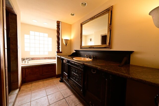 bathroom featuring a tub, vanity, and tile patterned flooring