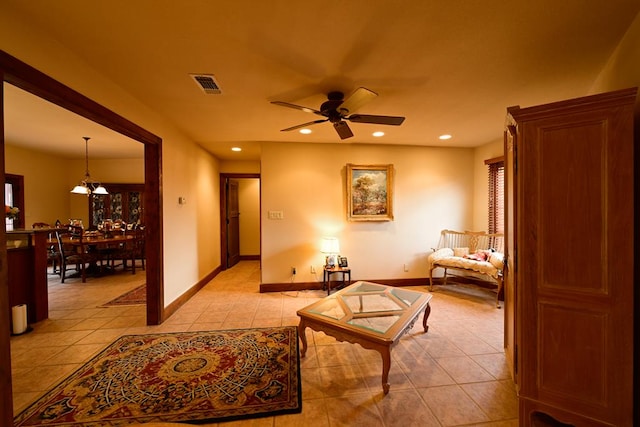 sitting room featuring light tile patterned floors and ceiling fan with notable chandelier