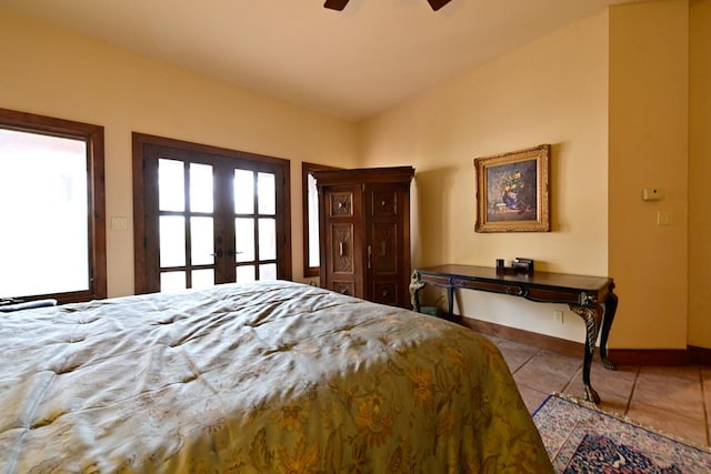 bedroom with ceiling fan, light tile patterned floors, and lofted ceiling