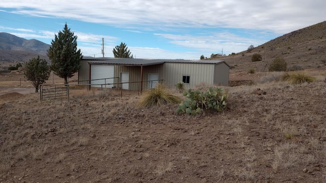 back of property with an outbuilding, a mountain view, and a garage