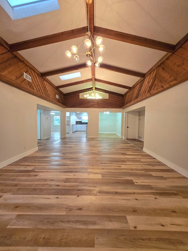 2500 Roper St, Odessa, TX 79761 - spare room featuring a chandelier, a skylight, and wood finished floors