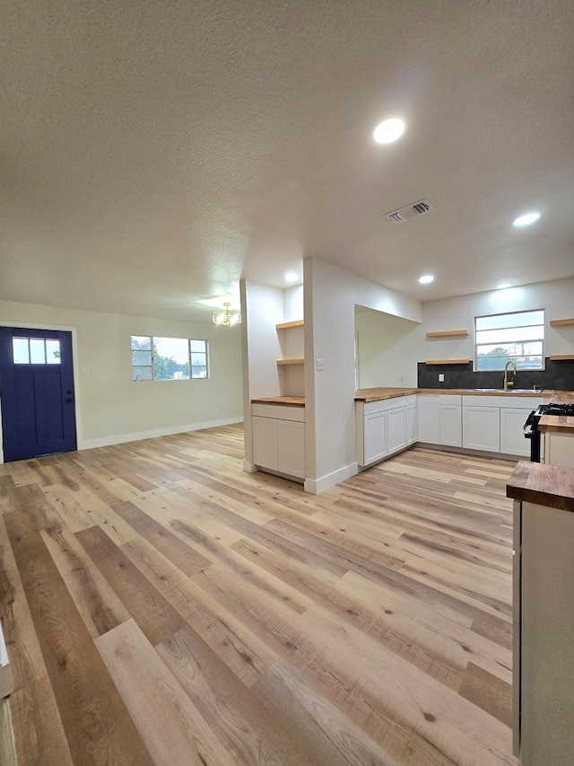 2500 Roper St, Odessa, TX 79761 - kitchen featuring open shelves, open floor plan, white cabinets, light wood finished floors, and recessed lighting