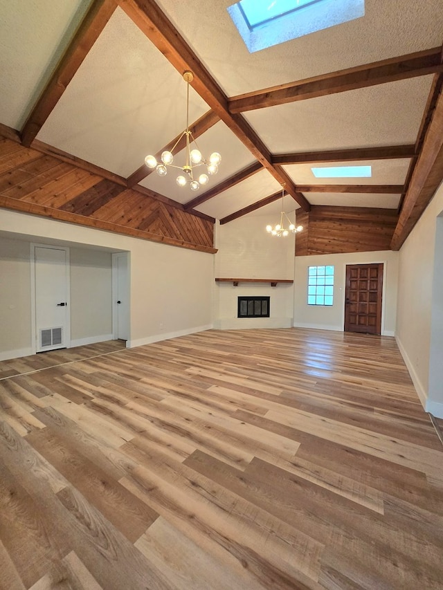 2500 Roper St, Odessa, TX 79761 - unfurnished living room featuring a chandelier, a skylight, and wood finished floors