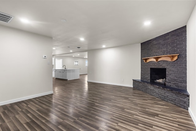 622 W Hillmont Rd, Odessa, TX 79764 - unfurnished living room with recessed lighting, a fireplace, and dark wood finished floors
