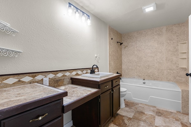 622 W Hillmont Rd, Odessa, TX 79764 - bathroom featuring vanity, shower / bathtub combination, tile walls, stone finish flooring, and a textured wall