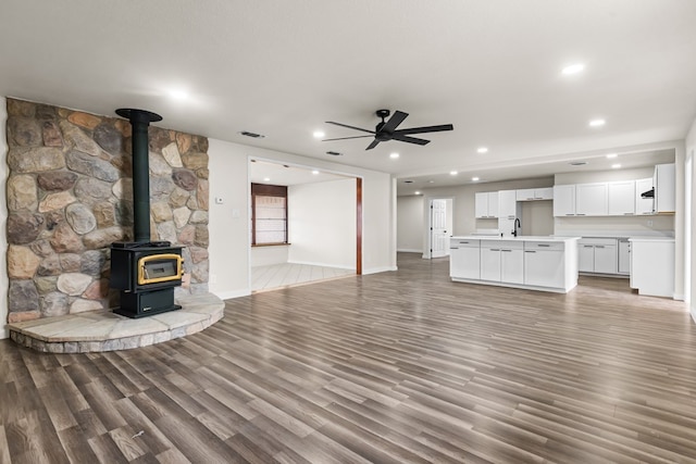 622 W Hillmont Rd, Odessa, TX 79764 - unfurnished living room with a wood stove, ceiling fan, light wood finished floors, and recessed lighting