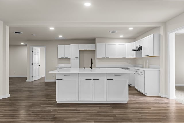 622 W Hillmont Rd, Odessa, TX 79764 - kitchen featuring under cabinet range hood, a kitchen island with sink, dark wood finished floors, white cabinets, and recessed lighting