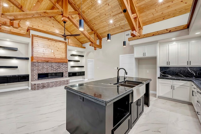 8634 Luz Dr, Odessa, TX 79765 - kitchen featuring wood ceiling with exposed beams, light marble finish floors, a sink, high vaulted ceiling, and open floor plan