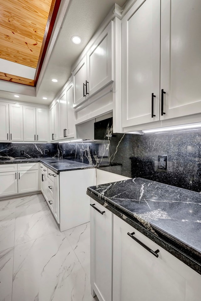 8634 Luz Dr, Odessa, TX 79765 - kitchen featuring white cabinets, light marble finish floors, recessed lighting, tasteful backsplash, and a tray ceiling