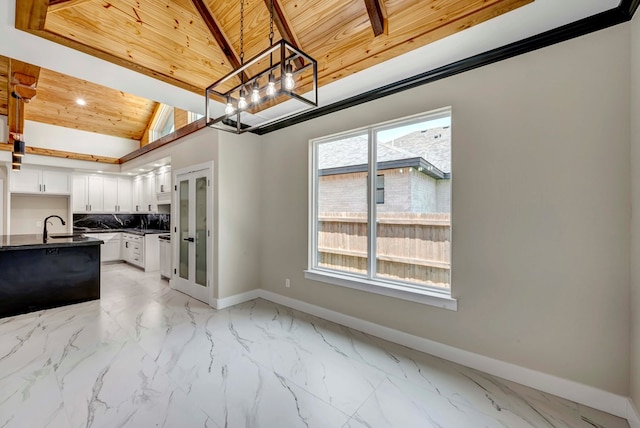 8634 Luz Dr, Odessa, TX 79765 - kitchen with dark countertops, baseboards, a chandelier, a sink, and wooden ceiling