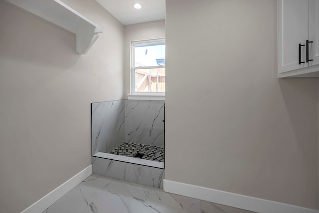 8634 Luz Dr, Odessa, TX 79765 - bathroom featuring baseboards, marble look tiles, and a marble finish shower