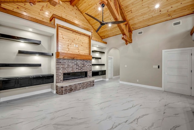 8634 Luz Dr, Odessa, TX 79765 - unfurnished living room with wood ceiling with exposed beams, arched walkways, ceiling fan, built in shelves, and marble finish floors