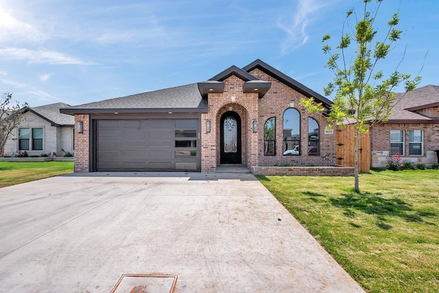 8634 Luz Dr, Odessa, TX 79765 - french provincial home featuring brick siding, an attached garage, driveway, and a front yard