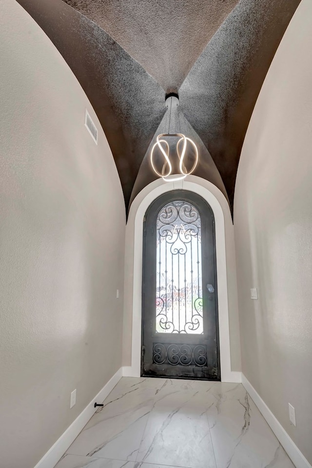 8634 Luz Dr, Odessa, TX 79765 - foyer with baseboards, marble finish flooring, arched walkways, a chandelier, and lofted ceiling