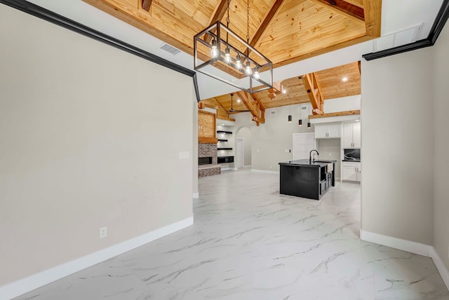 8634 Luz Dr, Odessa, TX 79765 - unfurnished living room with baseboards, arched walkways, light marble finish flooring, wooden ceiling, and a sink