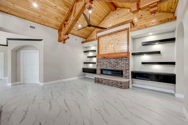 8634 Luz Dr, Odessa, TX 79765 - unfurnished living room featuring wooden ceiling with exposed beams, a ceiling fan, marble look tiles, arched walkways, and a brick fireplace
