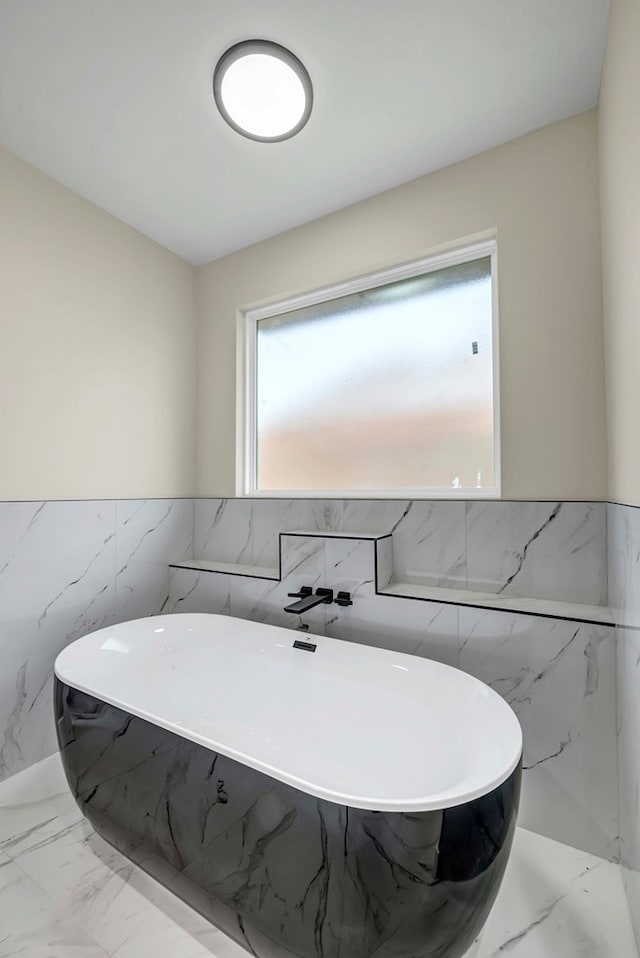 8634 Luz Dr, Odessa, TX 79765 - bathroom with tile walls, a freestanding bath, marble finish flooring, and wainscoting
