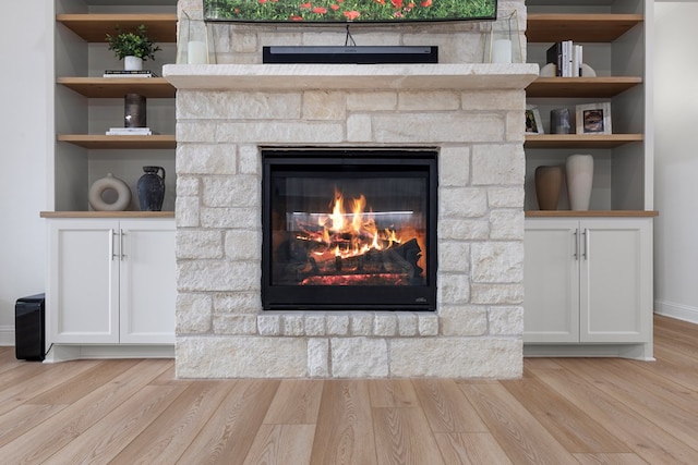 interior details featuring a fireplace, wood-type flooring, and built in features