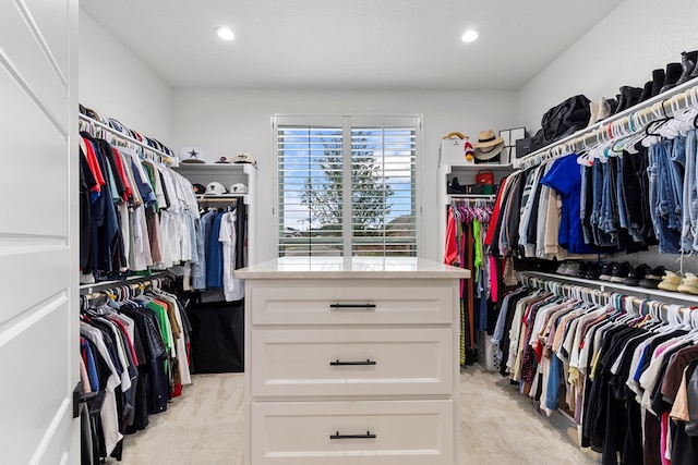 walk in closet with light colored carpet