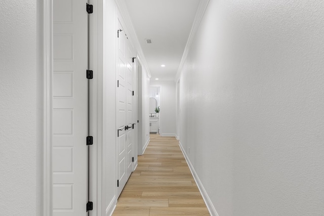 hall featuring crown molding and light wood-type flooring