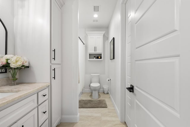 bathroom featuring tile patterned flooring, vanity, and toilet