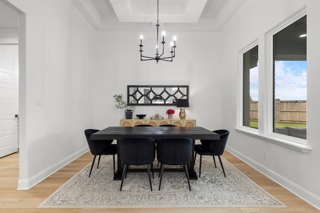 dining area with hardwood / wood-style flooring, a notable chandelier, ornamental molding, and a tray ceiling