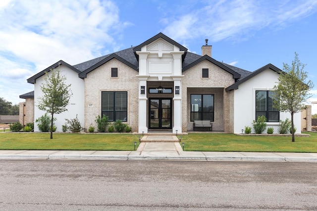 view of front of house featuring a front yard and french doors