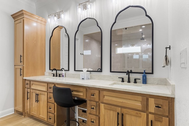 bathroom with a shower, hardwood / wood-style floors, vanity, and crown molding