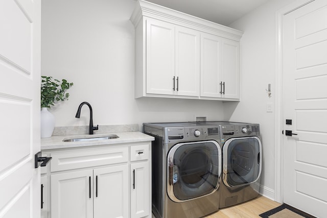 laundry room with cabinets, separate washer and dryer, light hardwood / wood-style floors, and sink