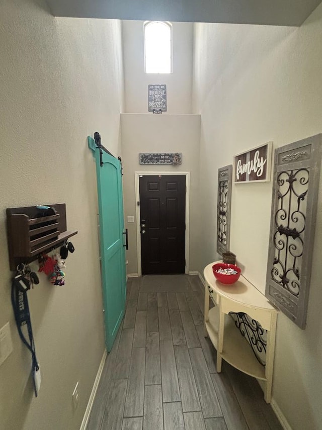 6912 Boss Rnch, Odessa, TX 79765 - entryway featuring wood finished floors, baseboards, a towering ceiling, and a barn door