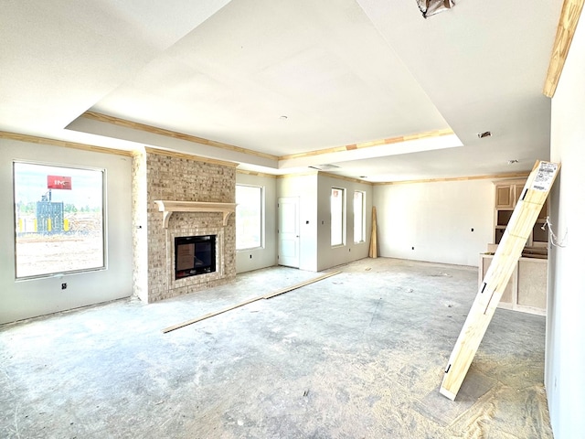44 La Fauna Dr, Odessa, TX 79765 - unfurnished living room featuring a tray ceiling and a fireplace