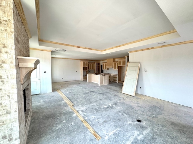 44 La Fauna Dr, Odessa, TX 79765 - unfurnished living room featuring a raised ceiling and a fireplace