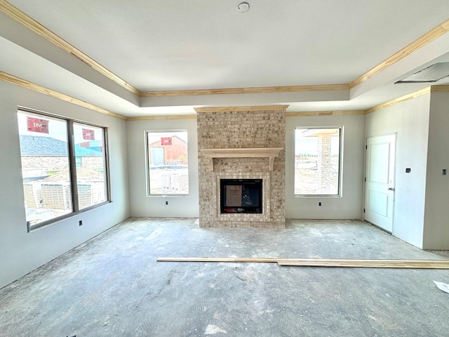 44 La Fauna Dr, Odessa, TX 79765 - unfurnished living room featuring crown molding, plenty of natural light, a tray ceiling, and a fireplace