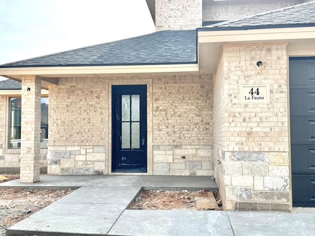 44 La Fauna Dr, Odessa, TX 79765 - view of exterior entry with a shingled roof and brick siding