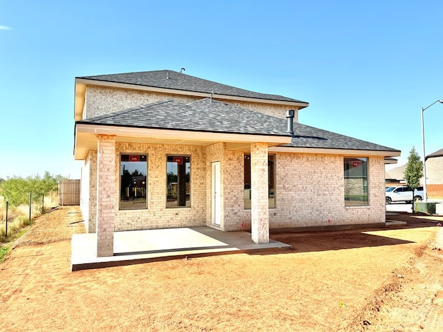 44 La Fauna Dr, Odessa, TX 79765 - rear view of house with a shingled roof, a patio area, and brick siding